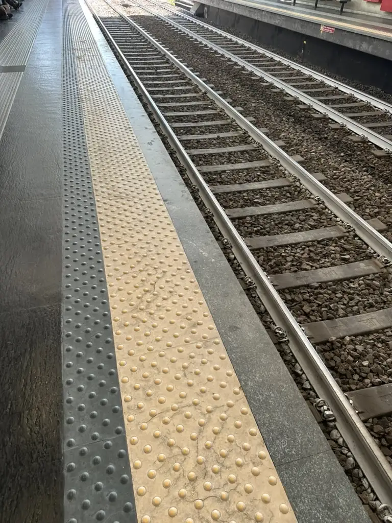 La striscia gialla tattile sulla banchina di una stazione ferroviaria